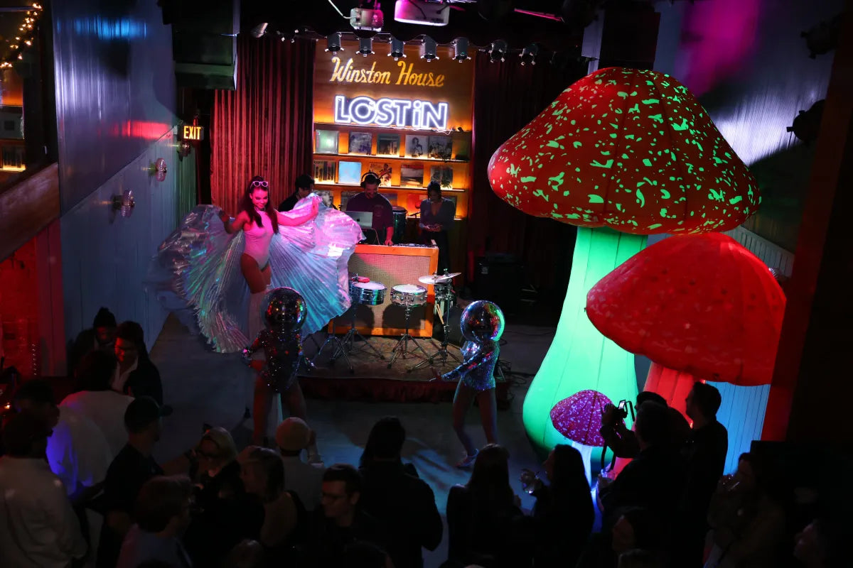 Nightclub performance with dancers, DJs, and glowing mushroom props at Winston House.